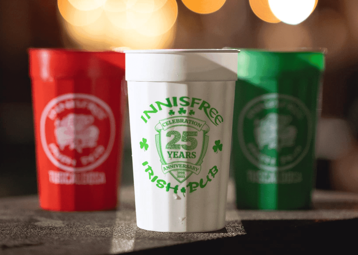 Green Innisfree Irish Pub stadium cups lined up on the bar